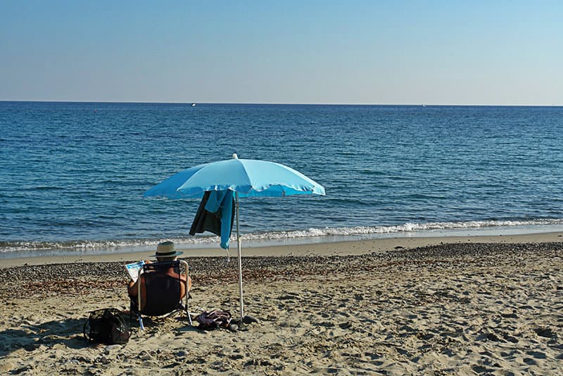 A man is enjoying the sun in the beach of Bussana