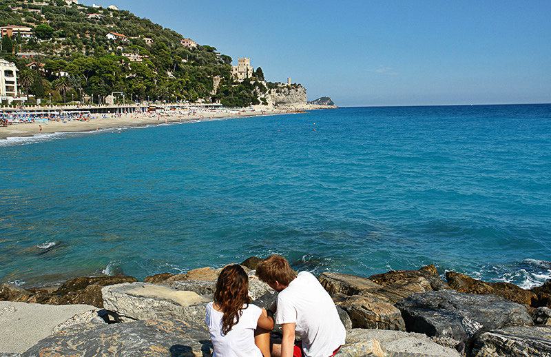 A couple is enjoying the view of Castel Gavone in Finale Ligure