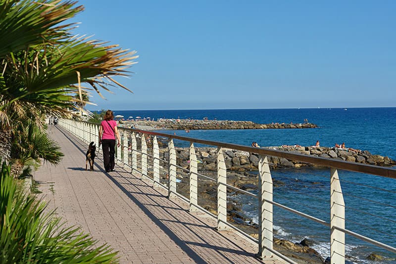 A woman walks along the coast in Riva Ligure